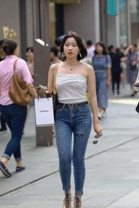 ​街拍：丰臀多姿的少妇，白色抹胸配时尚牛仔裤，十分有韵味！