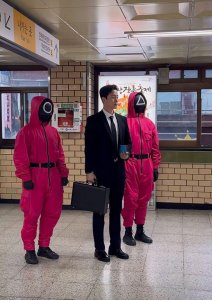 ​《鱿鱼游戏2》宣传团队打扮成剧中造型，在各地街头发邀请小卡片